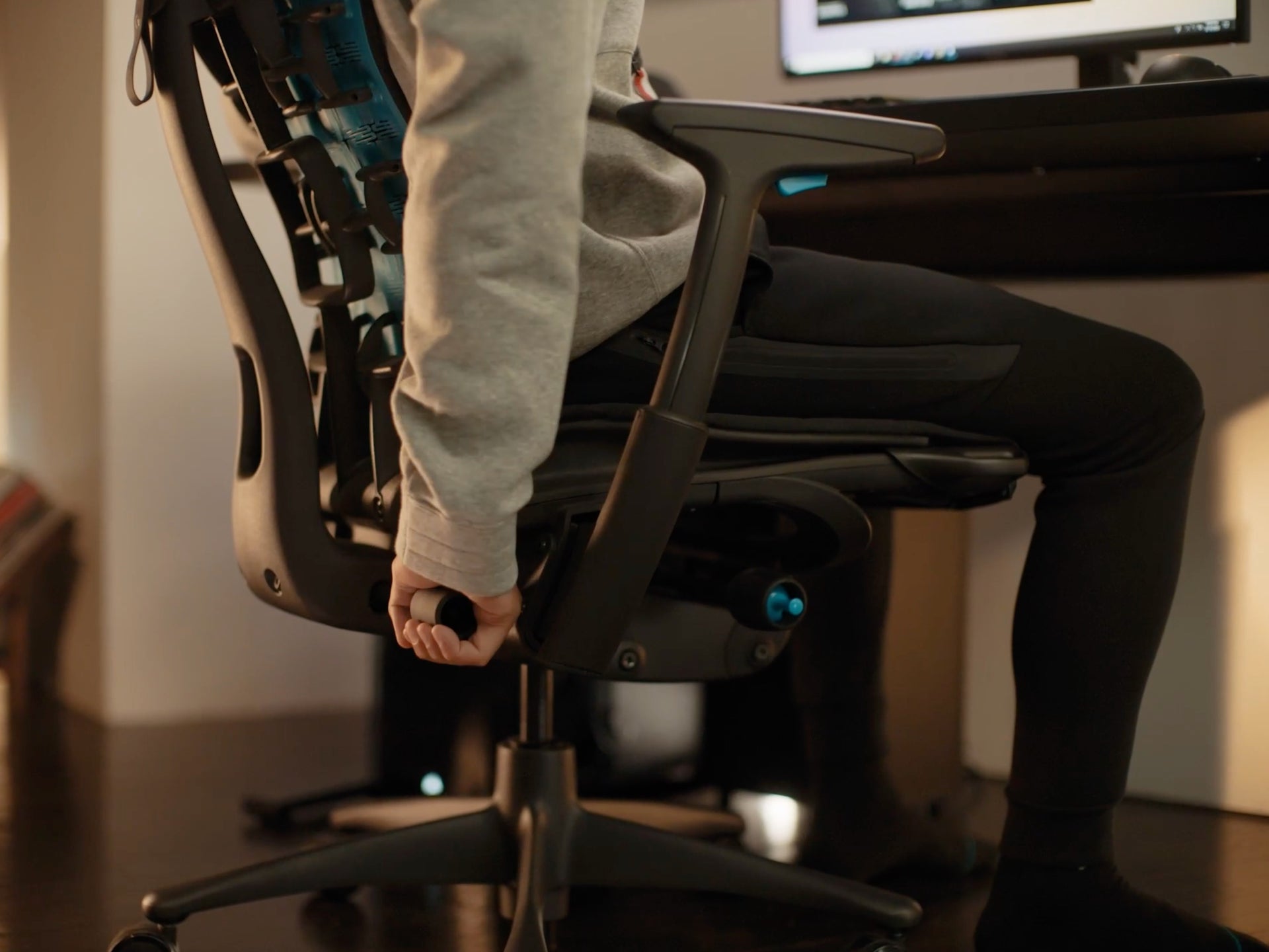 검은색 Embody Gaming Chair에서 Backfit을 조정하는 사람 손의 클로즈업 동영상.